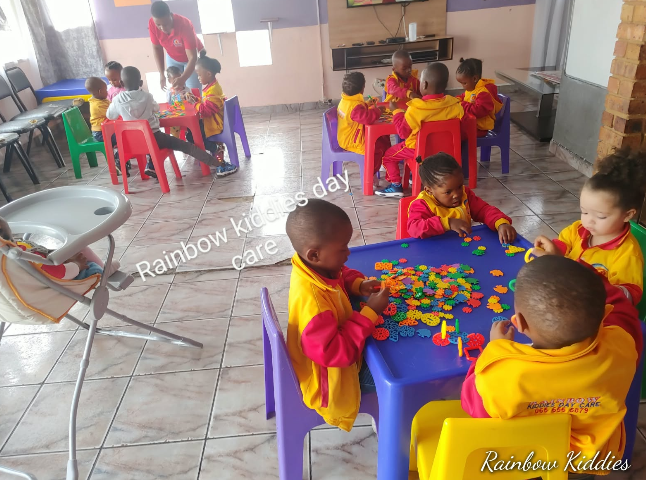 Rainbow Kiddies children playing and learning together at colourful tables