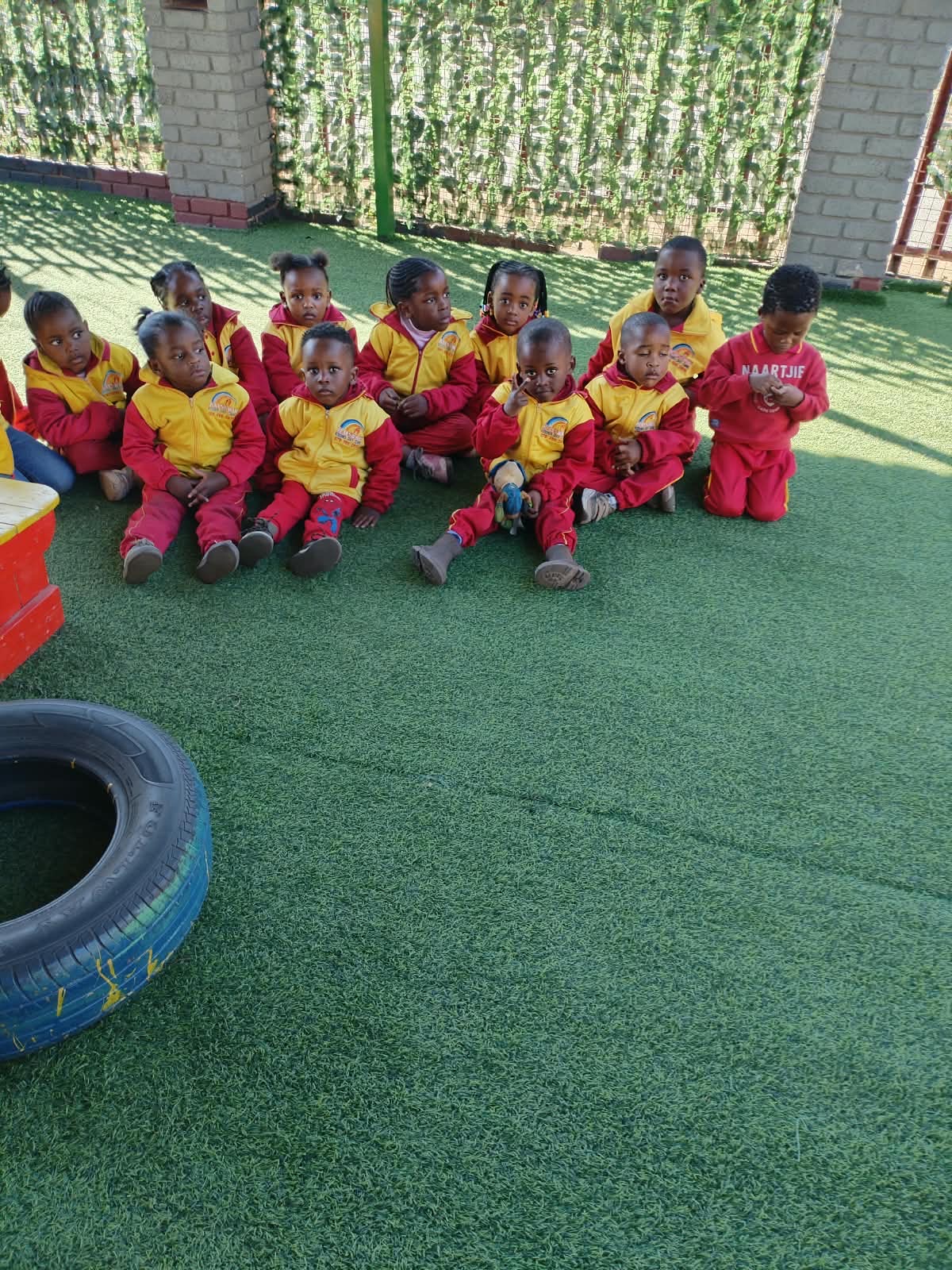 Rainbow Kiddies children seated together outdoors