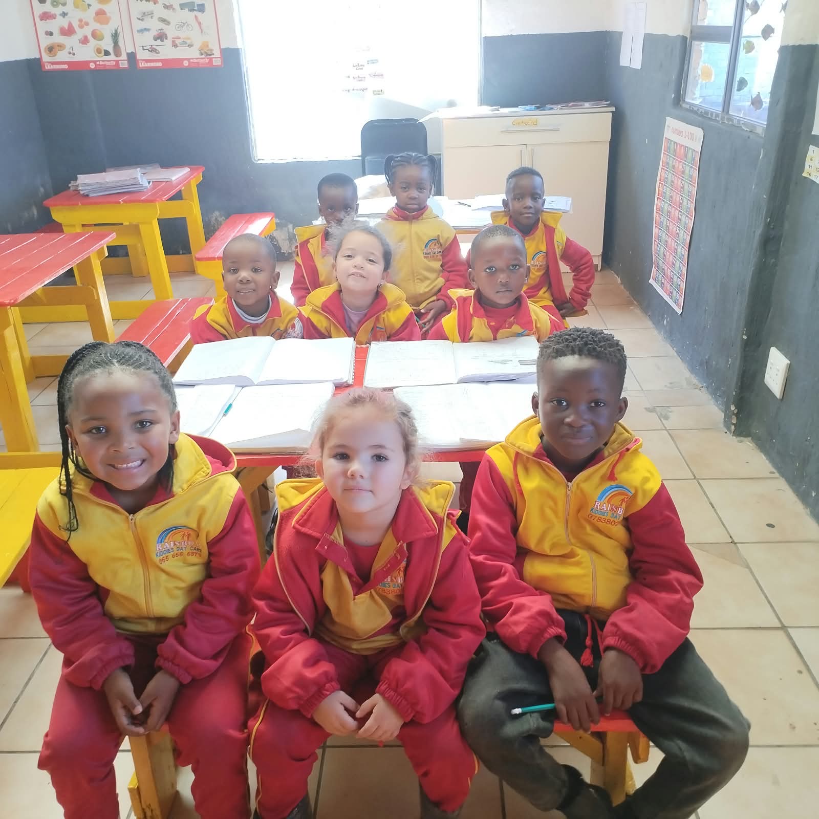 Children smiling in the Rainbow Kiddies classroom