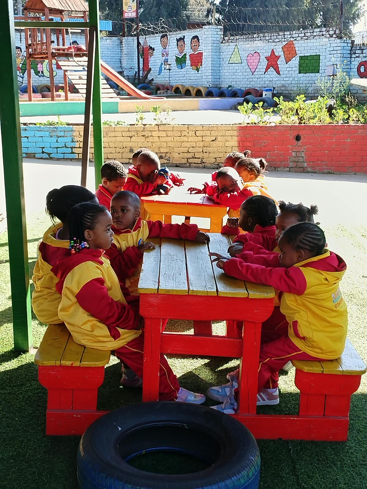 Rainbow Kiddies children together around the outdoor tables